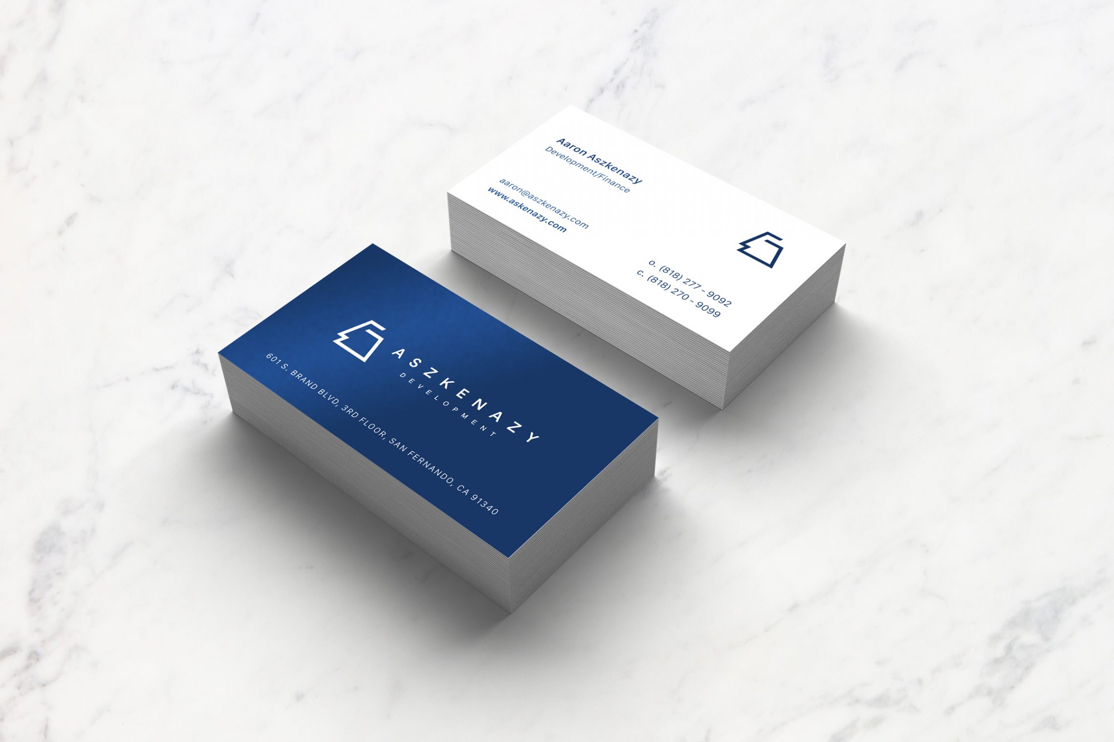 Aszkenazy Development business cards — deep-blue stock with the simplified mark and wordmark